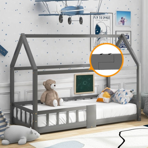 Das Bild zeigt ein Kinderbett in Form eines Hauses in einem liebevoll dekorierten Kinderzimmer. Das Bett ist grau und mit einer Matratze und mehreren Kissen ausgestattet. Ein brauner Teddybär sitzt auf dem Bett. An der Wand sind Weltraum-Poster und ein Modellflugzeug angebracht. Eine kleine Tafel hängt am Bett. Ein vergrößerter Ausschnitt zeigt ein Detail des Bettes in einem orangefarbenen Kreis.