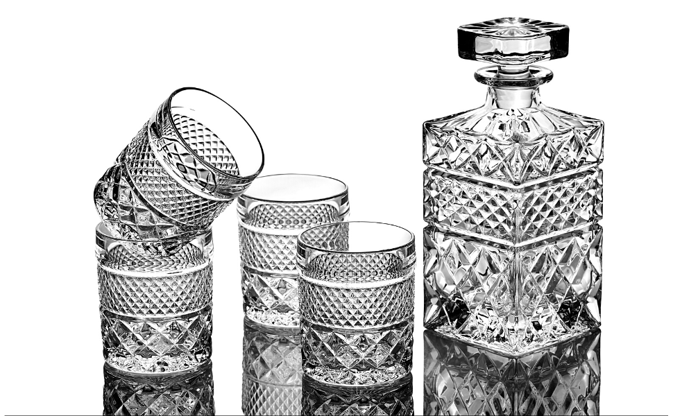 Elegant crystal whiskey decanter set with intricate patterns, featuring a decanter and four matching glasses in a classic design.